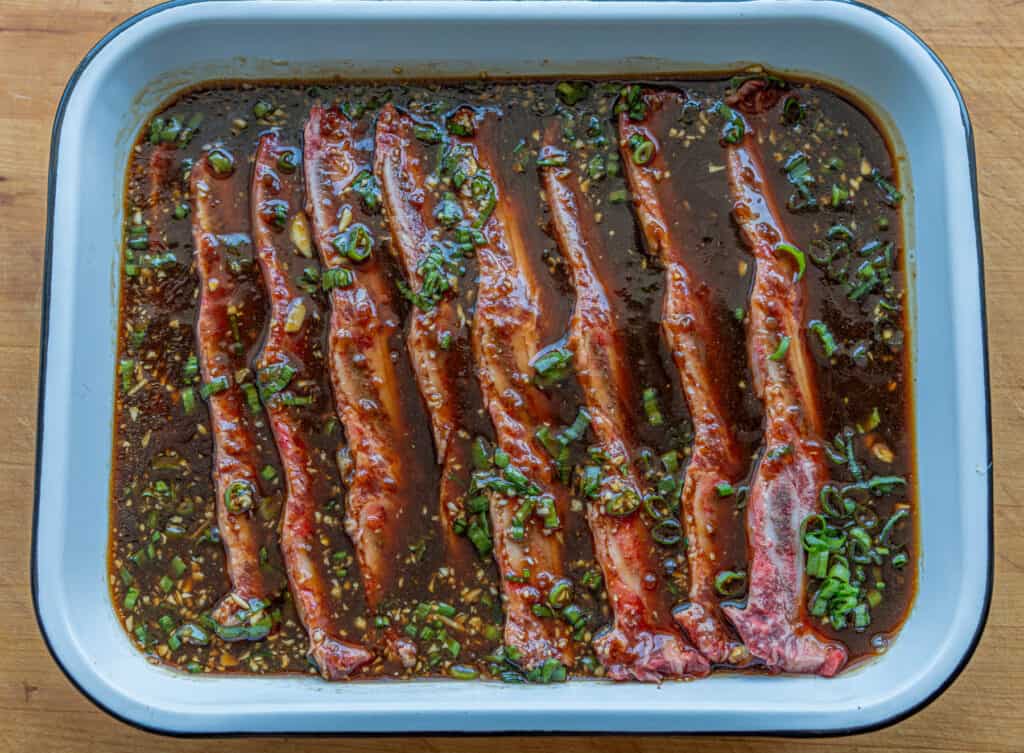 Uncooked Kalbi being marinated in a pan